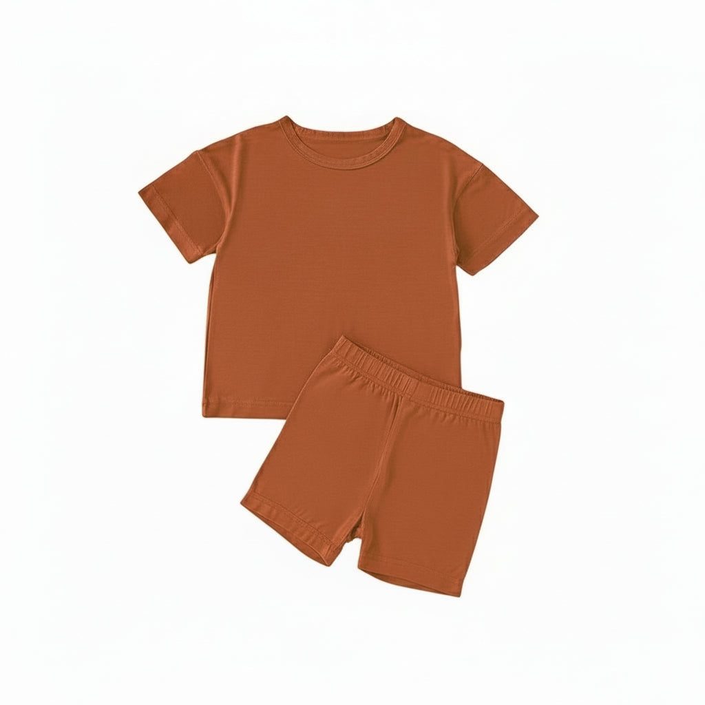 orange children's t-shirt and shorts set with shoes on a beige background