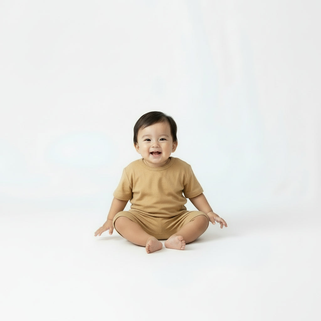Children's tan t-shirt and shorts set with brown shoes on a beige background