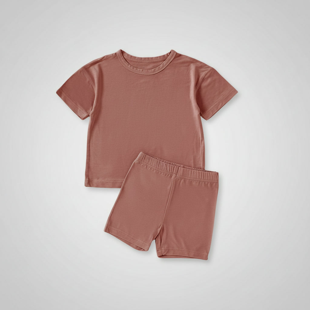 Children's pink t-shirt and shorts set with shoes on a beige background