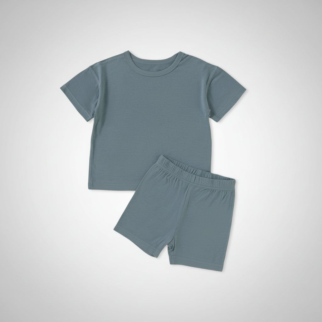 Children's blue outfit with shorts and shoes on a beige background